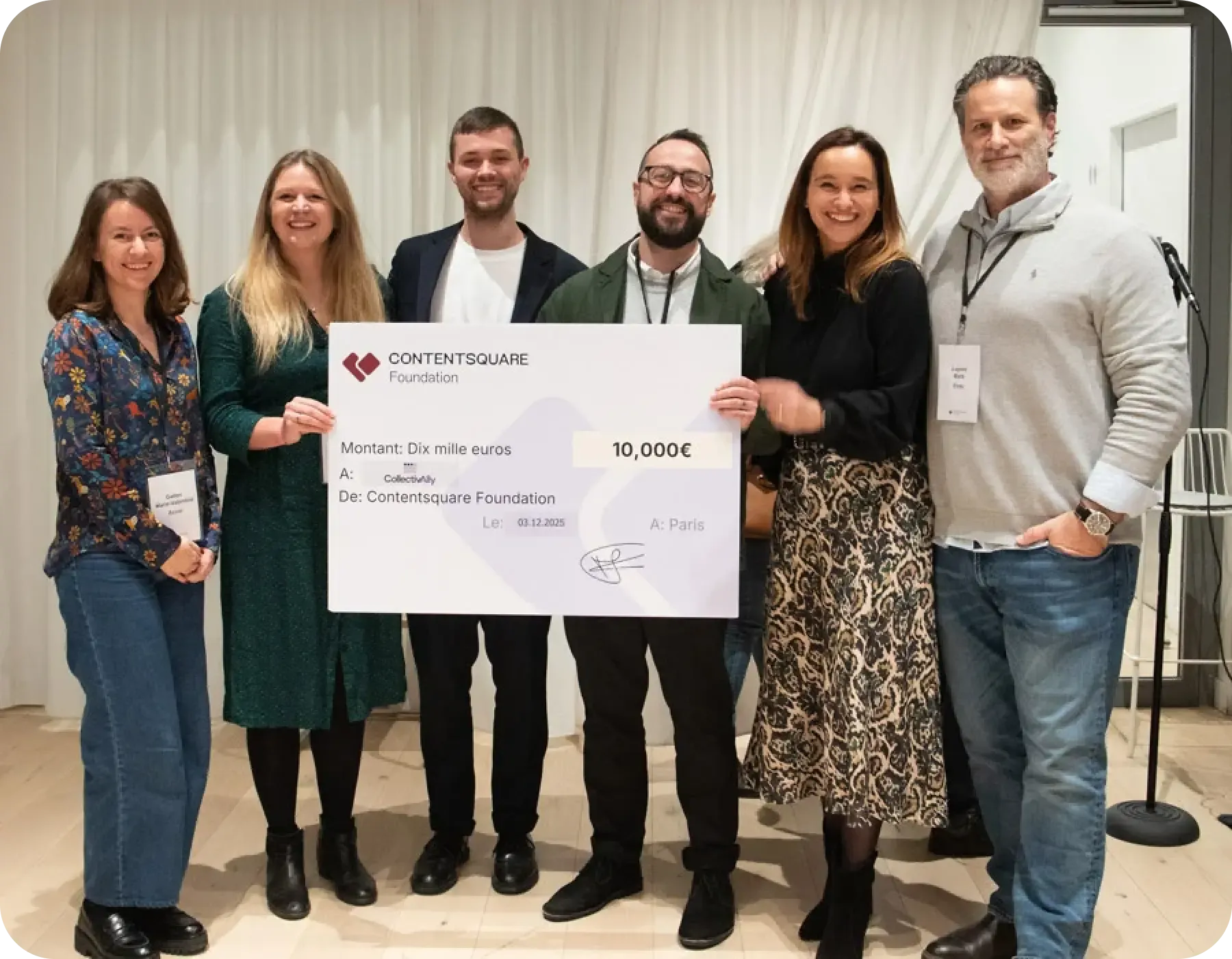 The CollectivAlly team stand alongside the judging panel holding a large cheque, all smiling broadly